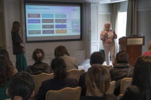 Two speakers in front of an audience delivering a presentation